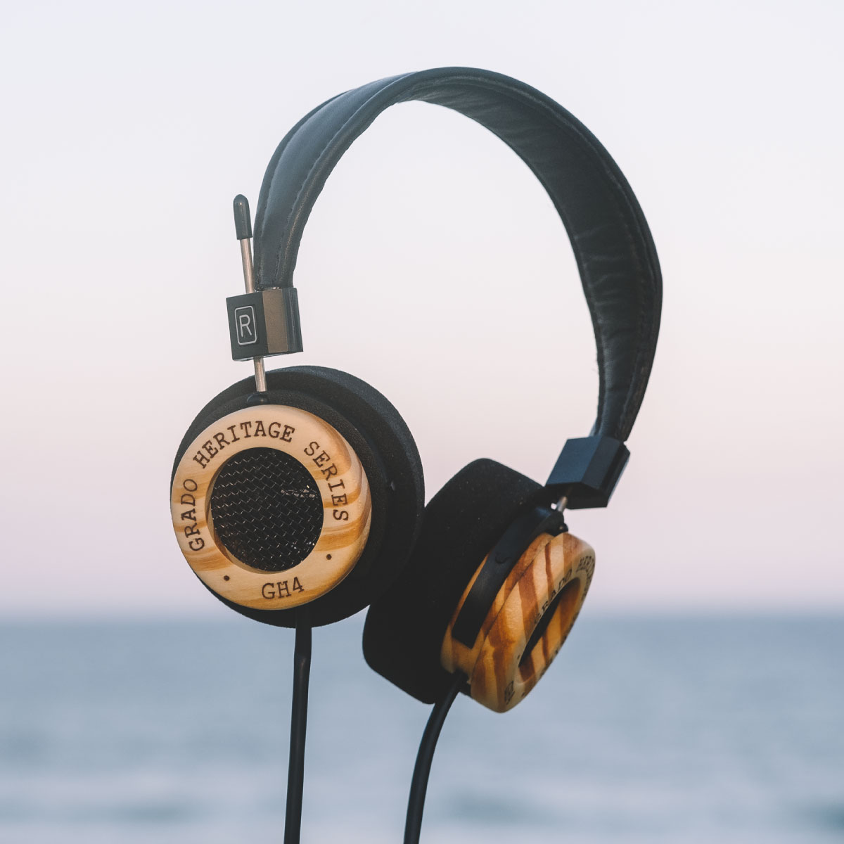Photo of GH4 Headphones levitating in front of scene of the ocean and sky
