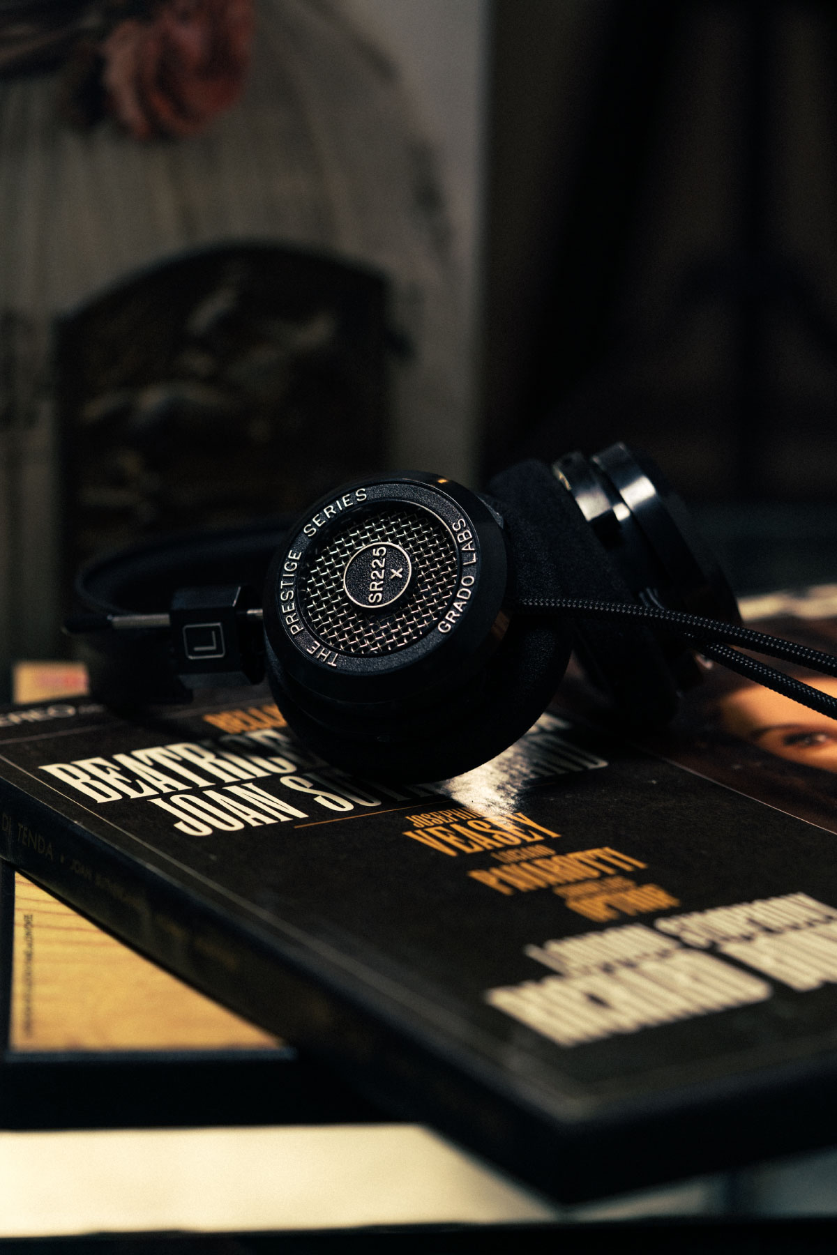 Photo of sr225x headphones resting on a black book in front of a mirror