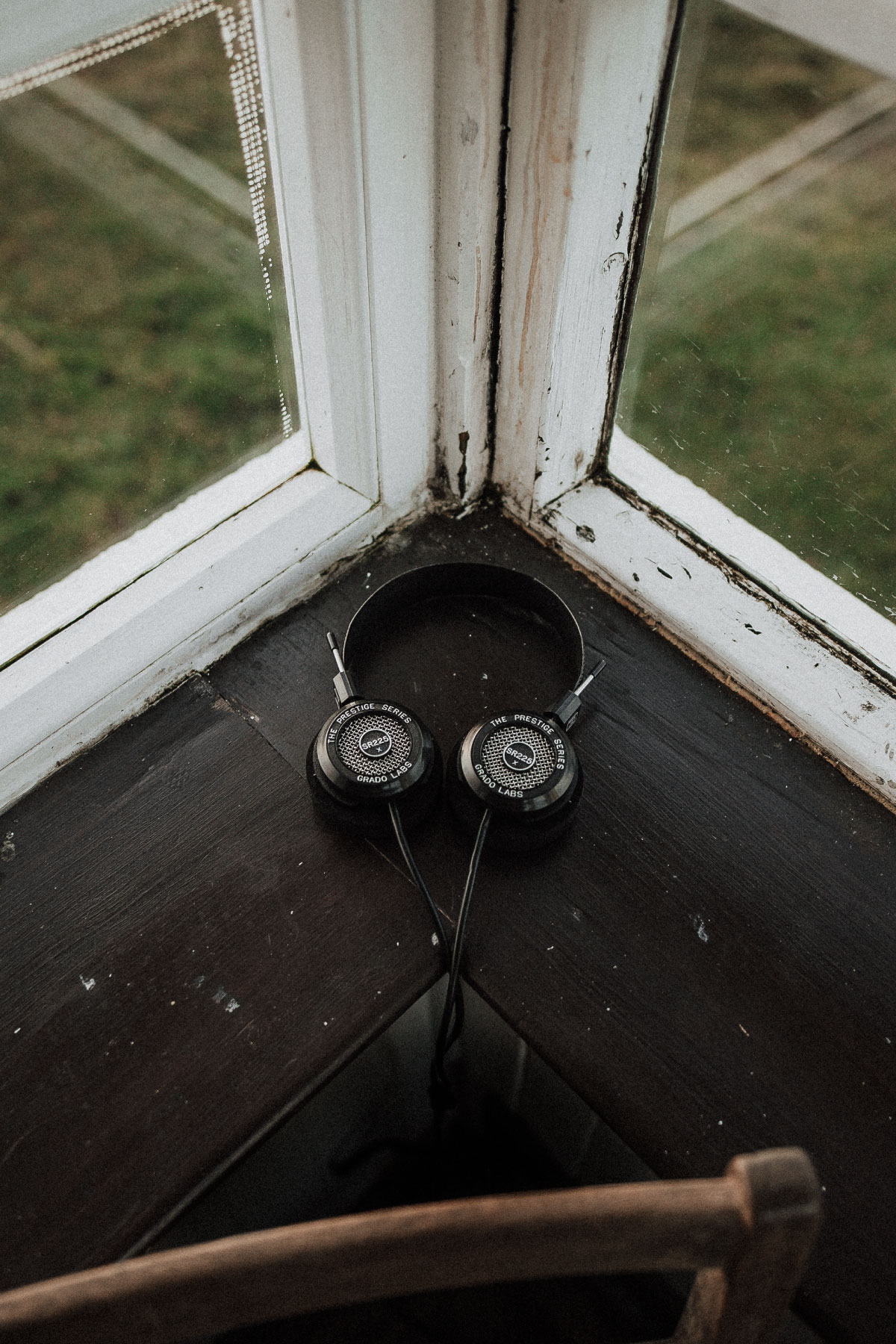 Photo of sr225x headphones resting on a corner where two windowsills meet.
